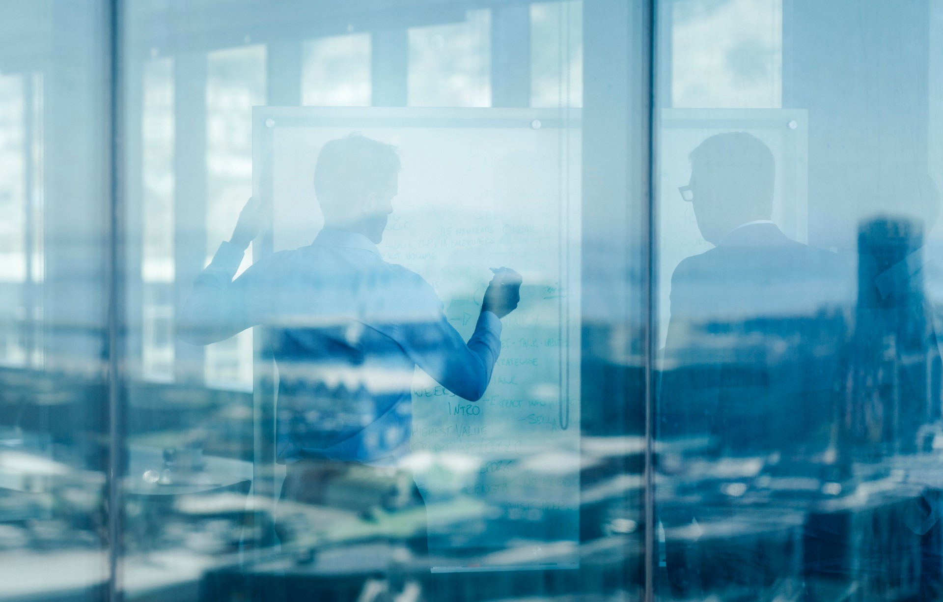 Businessmen in meeting seen through glass window